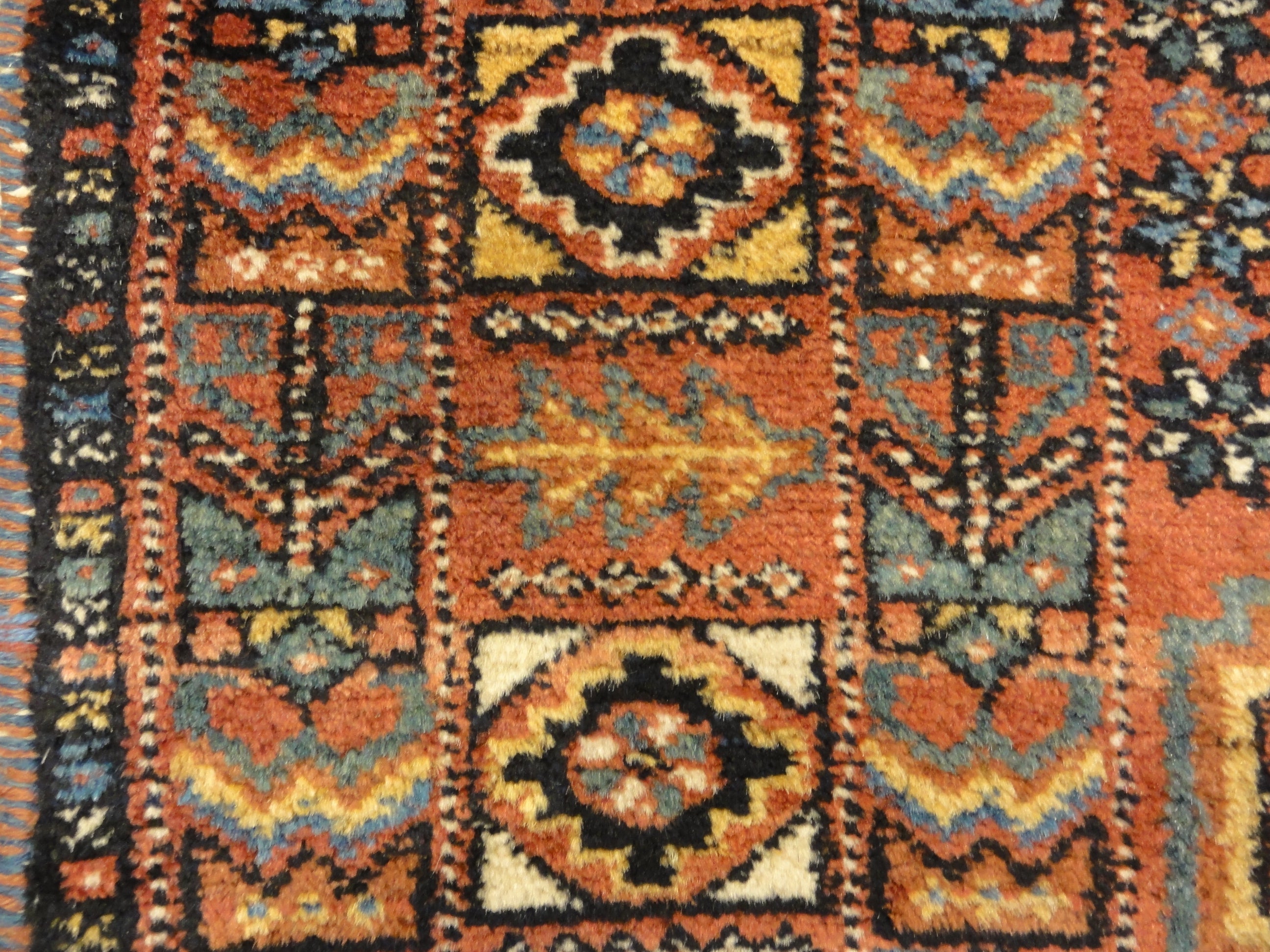 An antique Persian Afshar rug featuring a diamond pattern. A piece of genuine original woven carpet art sold by the Santa Barbara Design Center.