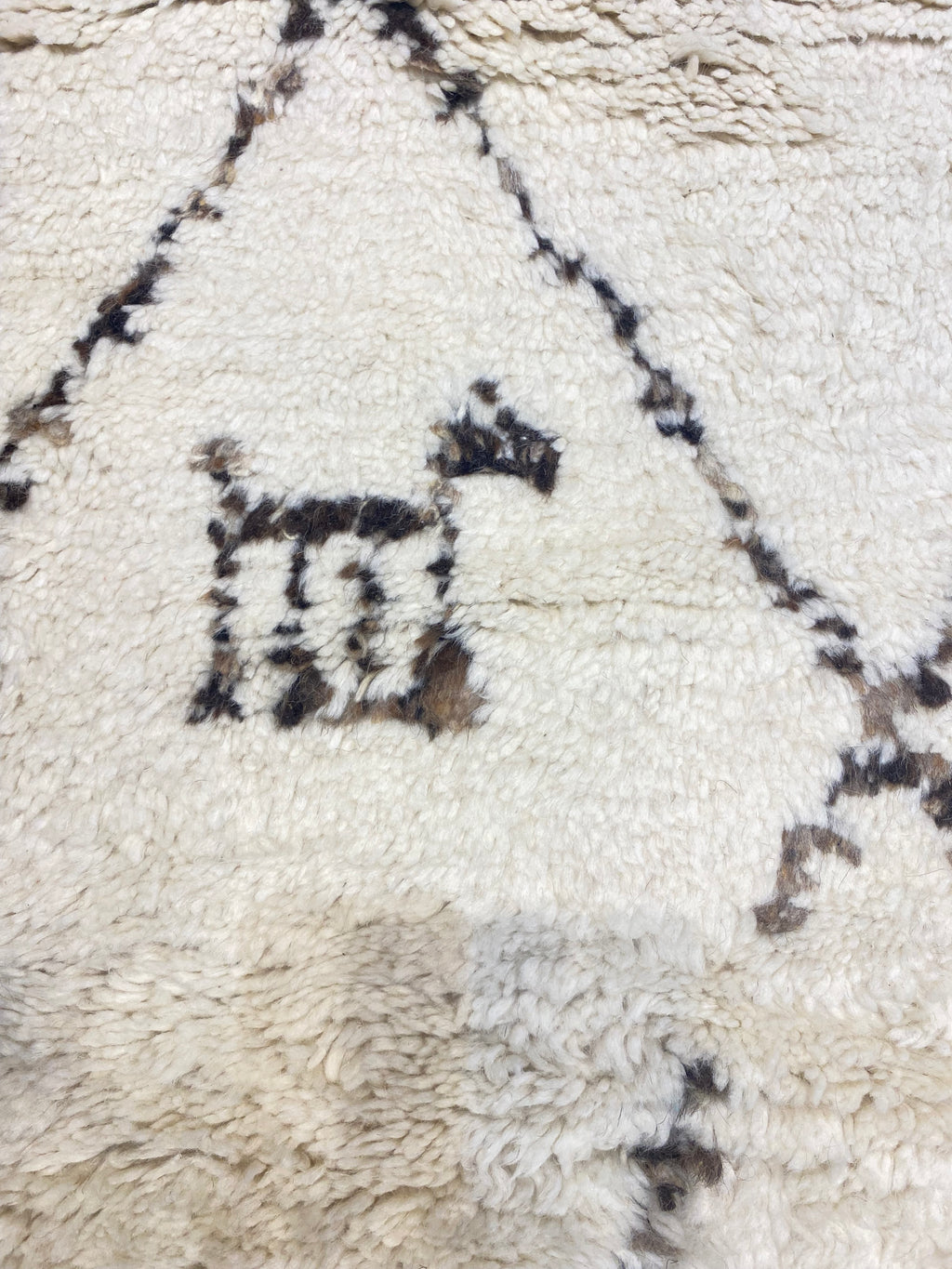 Close-up of Santa Barbara Chic Moroccan rug, featuring a minimalist black and white geometric design on a cream background.