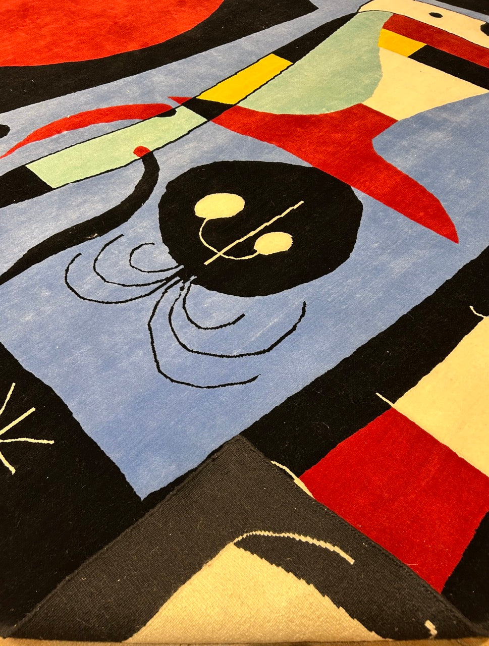 Abstract art piece with geometric shapes and colors on a textured surface