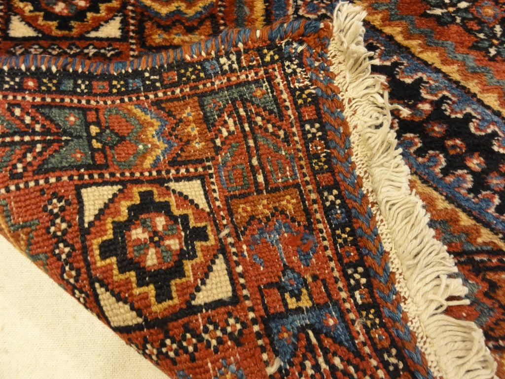 An antique Persian Afshar rug featuring a diamond pattern. A piece of genuine original woven carpet art sold by the Santa Barbara Design Center.